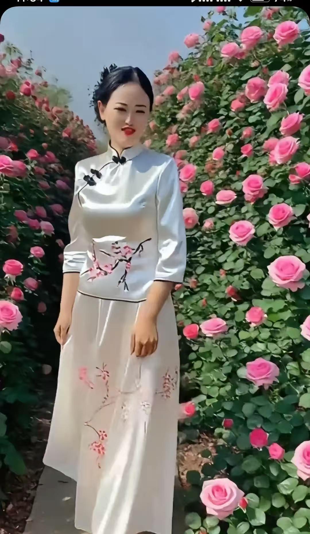 水仙子·旗袍赏玫
旗袍轻裹韵如弦，
梅影匀来色染鲜。
繁花夹道娇容现，
似春云映