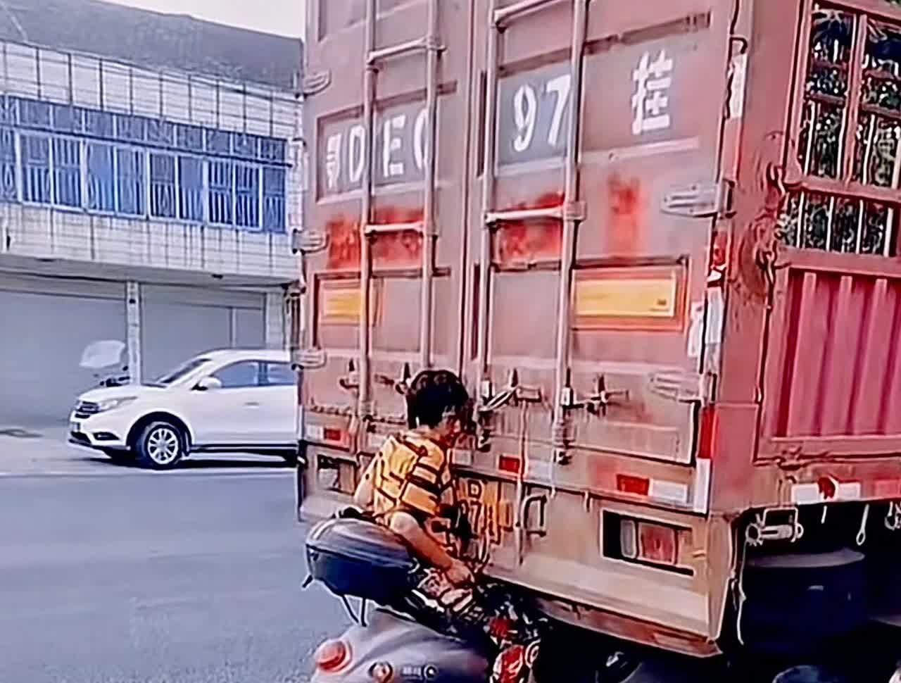 大妈能把电瓶车开成这样，也真的的确让人无语了，那么大一辆大货车停在马路边上都看不