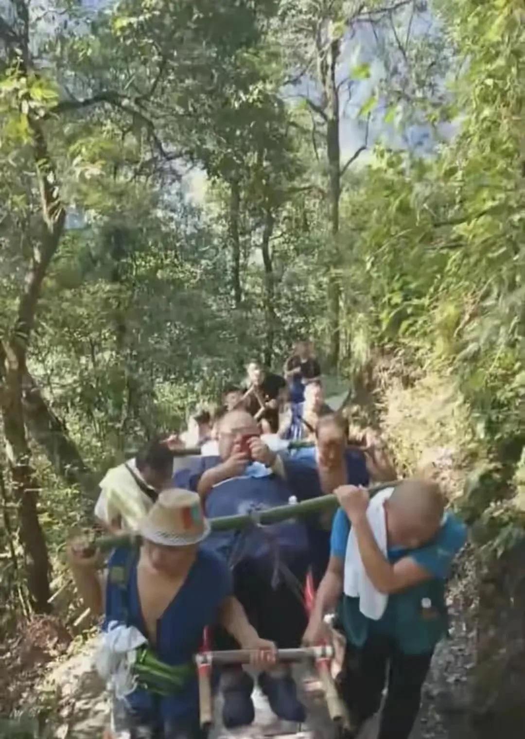坐在滑竿上的男子体重260多斤，雇了9名轿夫抬着他往返走了40多公里，花了10个