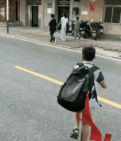 这个小同学太大意了，早上去上学，拽上红领巾就完外跑，还随手系在了书包上，今天我可