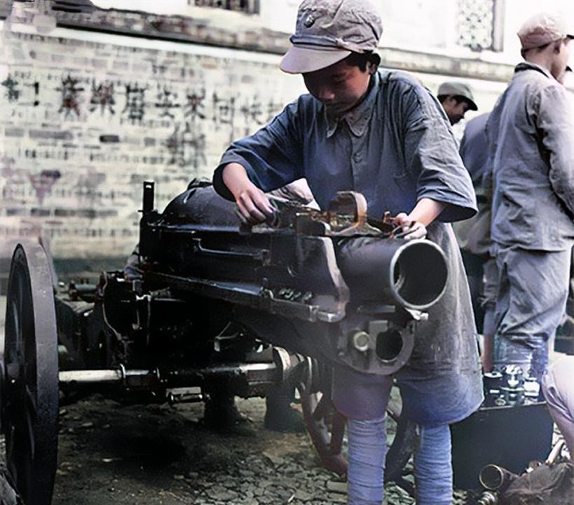 1945年5月74军一位娃娃兵奉命小心翼翼地擦拭着美式75毫米山炮 
