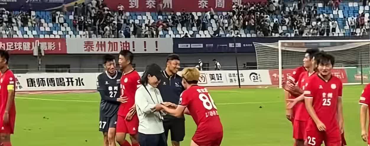 泰州队主教练周高萍对赛后过来打招呼的黄紫昌一阵敲头猛打，仿佛在说你这小子，早不上