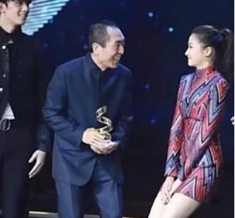 一次颁奖晚会上，张艺谋走向关晓彤时，只见她双腿紧闭，双手捂裙，双膝往下蹲。张艺谋