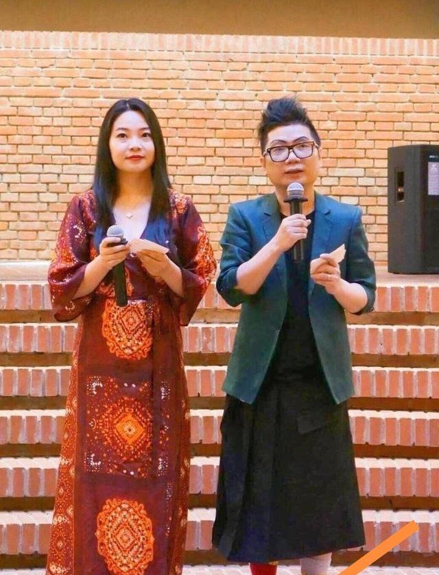 陈青松上身套着西服，下身却配了条黑色长裙，还搭了双大红色的长筒袜，这一身搭配实在