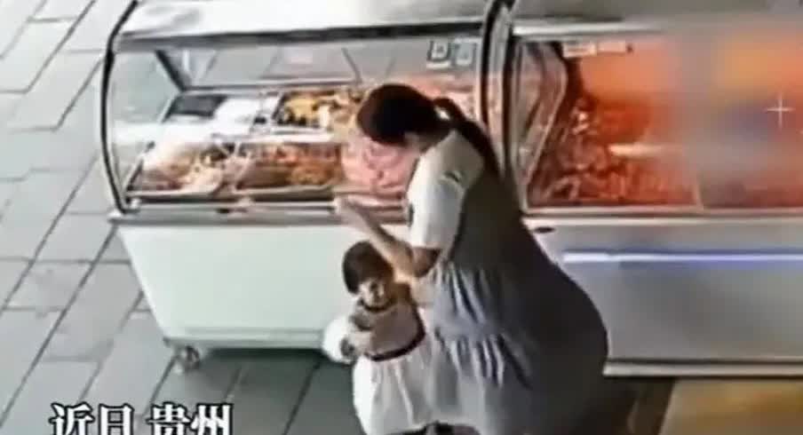 近日在贵州街边一熟食柜台前，一位女子带着一个小女孩站在柜台边，正当小女孩央求女子
