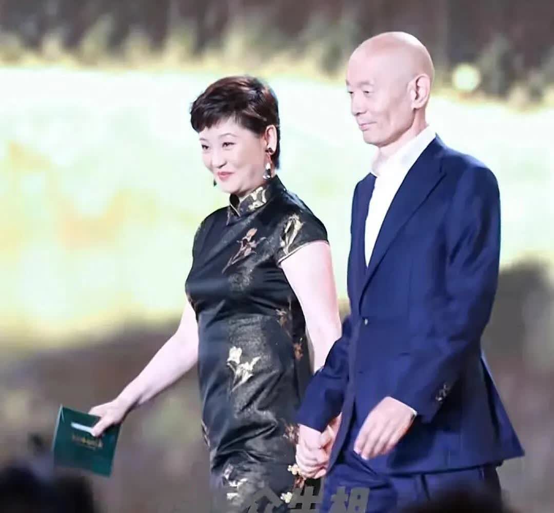 徐帆葛优十指紧扣上台颁奖，葛优：“冯小刚导演没来，拉拉手呗”，徐帆：“拉着呢拉着
