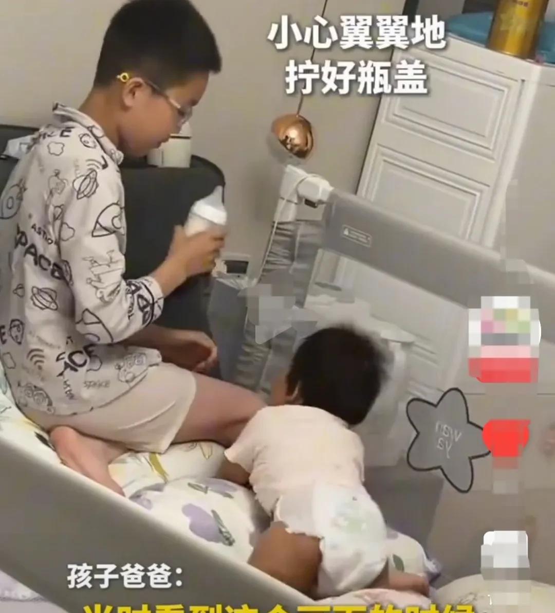 爸爸，下班回家推开门，看到让他暖心的一瞬。
10岁的小哥哥替10个月大的小妹妹，