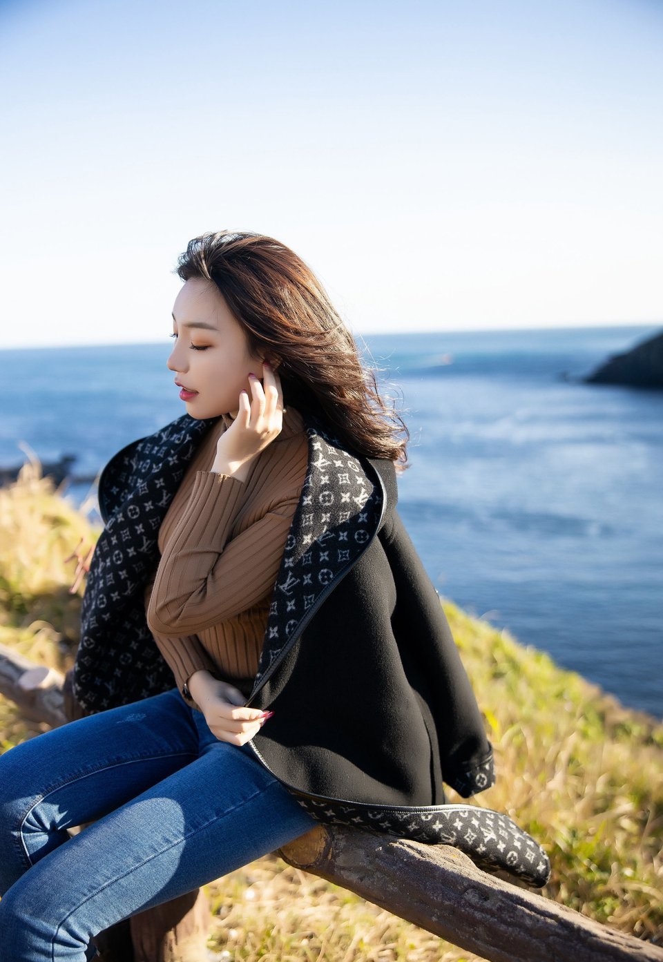 穿针织衫配牛仔裤的长腿美女