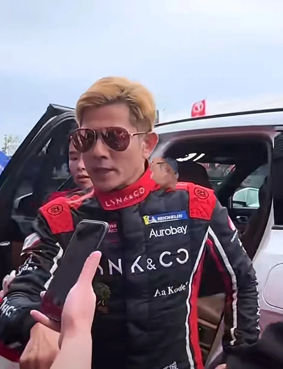 郭富城一身给红色骑行服亮相，真的又飒爽又帅气，黄色的头发整齐干净，茶色眼镜，五官