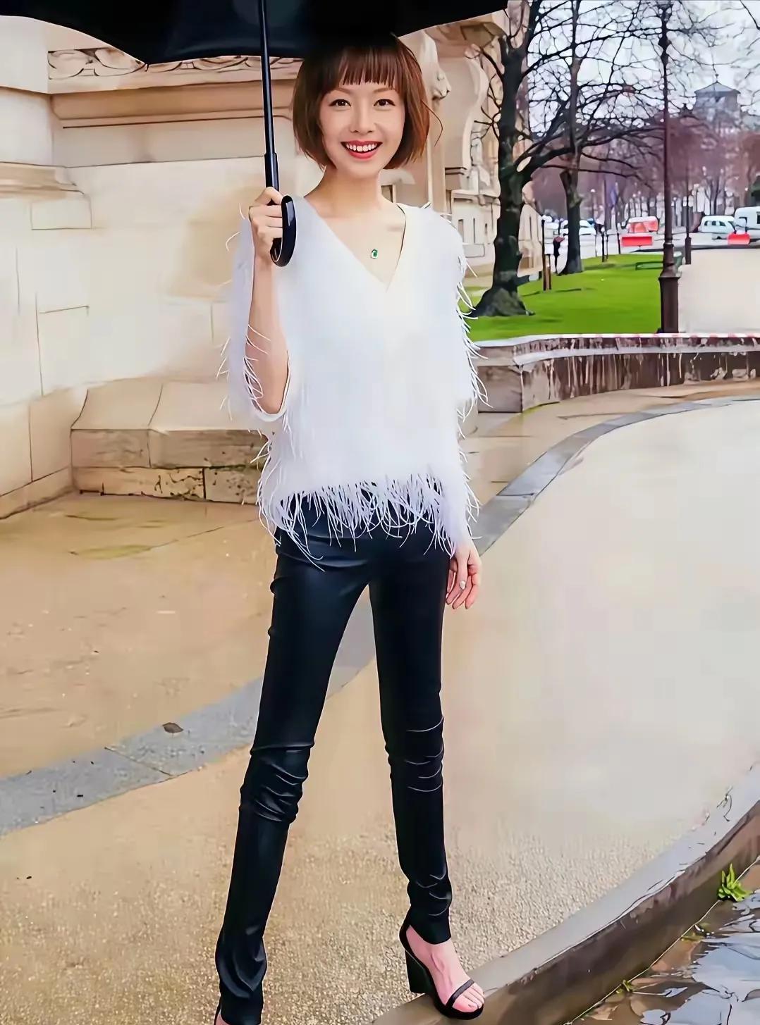 陈鲁豫，高光时刻，雨中漫步，伞下微笑，街头捕捉时尚瞬间。