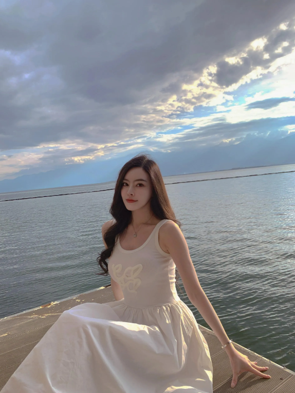 在海边，穿白色连衣裙的少女，温柔宁静。