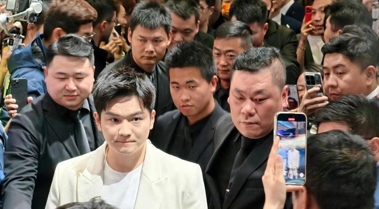 就在王励勤当选新一届乒协主席的当天，樊振东以一身亮眼的白色西装现身上海车展，被一