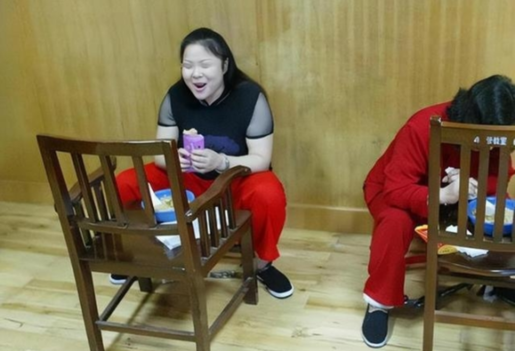 2003年武汉刑场，死刑犯何秀玲身着褪色红裤昂首前行，在灰暗场地格外扎眼。她曾为