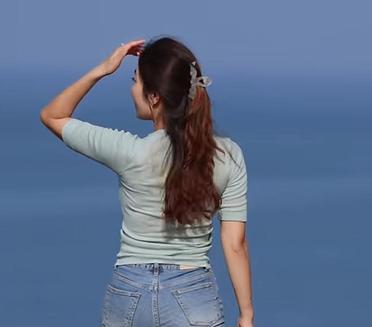 哇，这海景太赞了！她站在那儿，背影迷人，仿佛整个世界都是她的舞台。