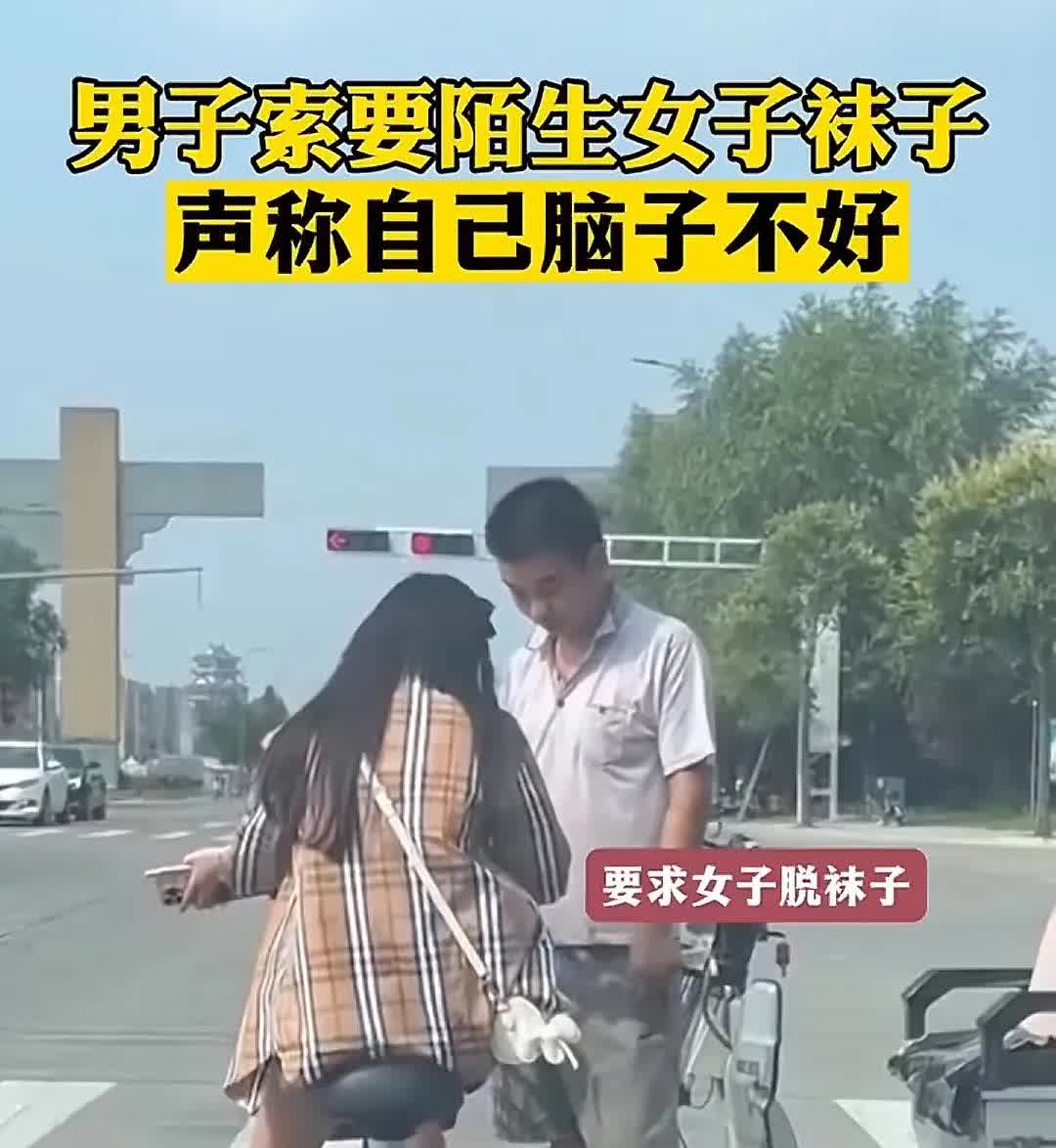 一男子在红绿灯前，趁着车辆等红绿灯之际向一陌生女子索要袜子，并声称自己脑子不好使