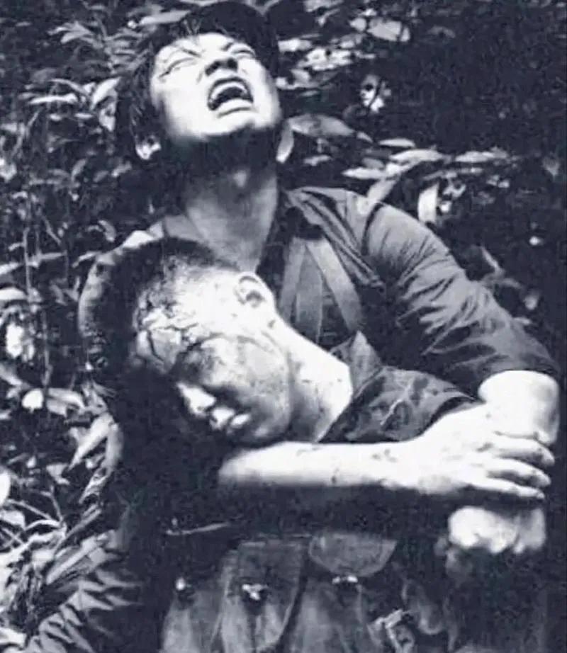 1984年，对越自卫反击战的211高地上，一名士兵头部中弹牺牲，他的战友抱着他的