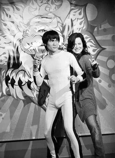 李小龙的女儿和李小龙蜡像一起合影，看李小龙女儿开心微笑摆出和李小龙一样的造型。