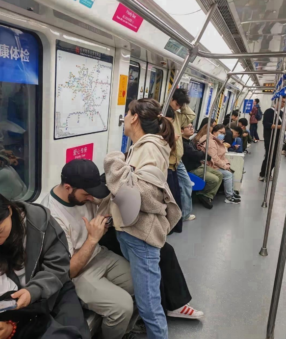 在中国的地铁上，这一幕令人深思：一位女子毫不犹豫地站起身，将座位让给了身旁的外国