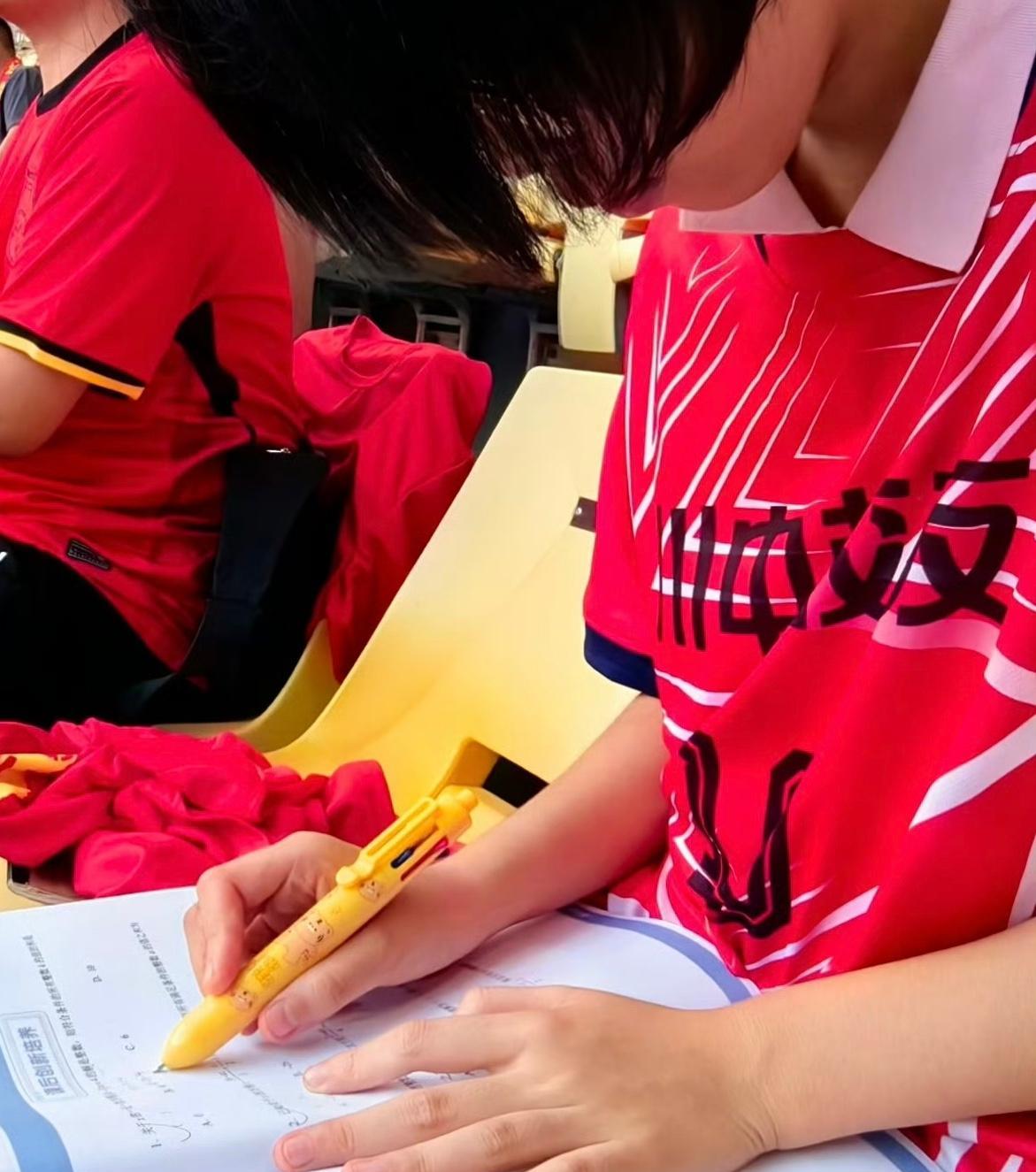 小球迷在国足世预赛比赛场上做题，好在国足总算赢球了！
6月10日晚，世预赛国足对