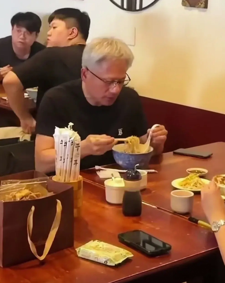 黄仁勋吃拉面还真有意思。一手拿筷子，一手吗勺子，先是用筷子把面条挑到勺子上，然后