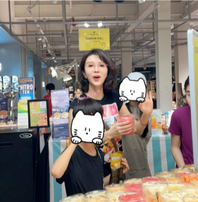 50岁金巧巧和子女现身马来西亚旅游，一家人到超市购物。她留着一头卷发，身材很瘦，