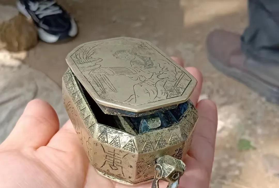 家人们，今儿个淘到个稀罕小物件！这古铜色的小盒子，八角造型，盖子上还刻着人物图案