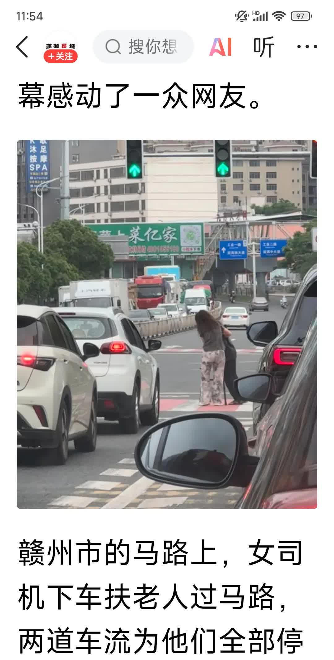 感动，
赣州市的马路上，
一位热心的女司机，
扶老人过马路，
两道车流为