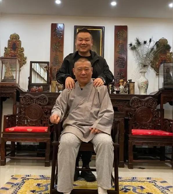 标题郭德纲形象：郭德纲坐在一张古朴的中式圆桌旁，身着传统大褂，颜色可以是深色系如