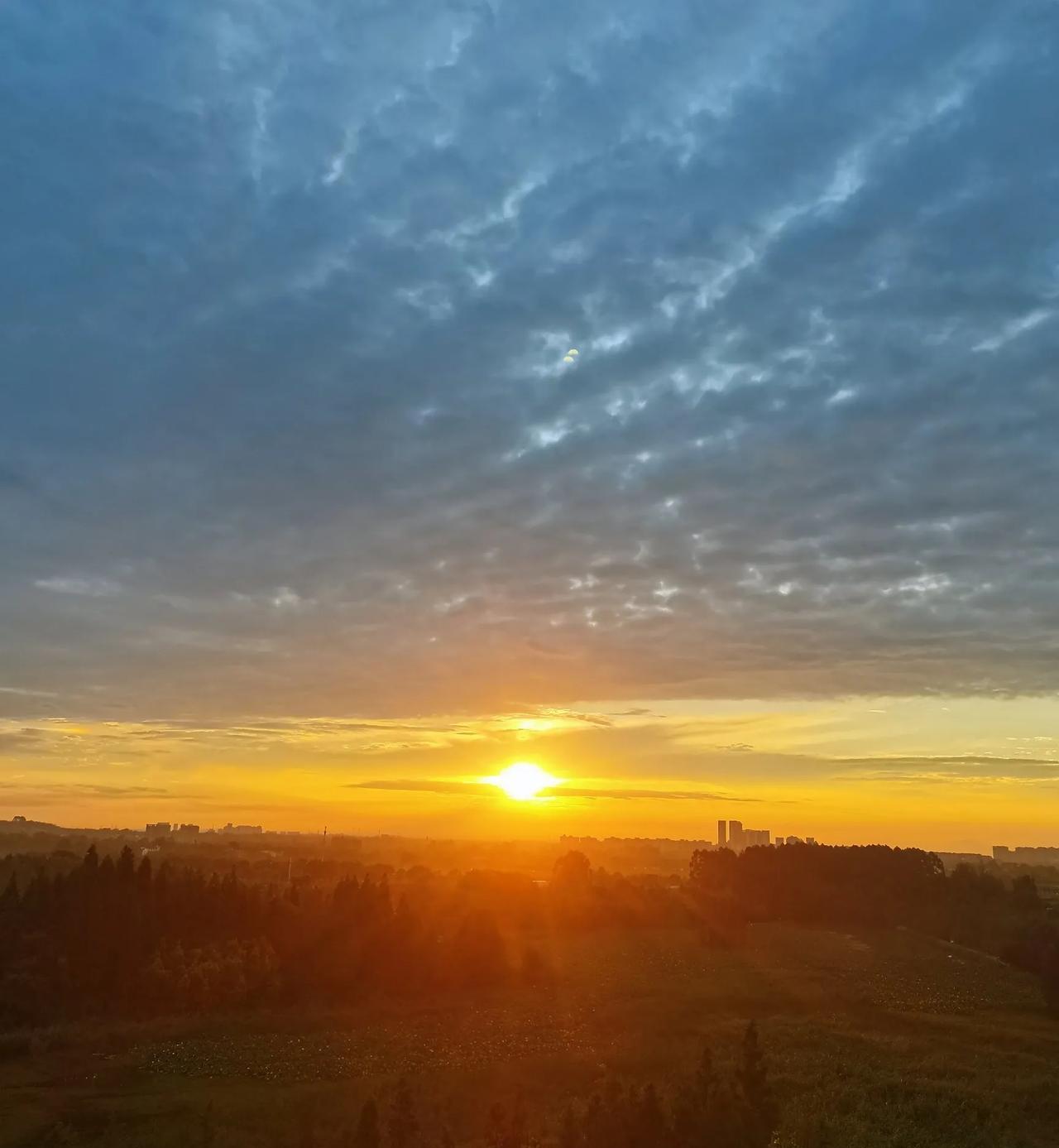 成都，早上6:10分，太阳正从厚厚的黑色云层里挣脱出来，万丈光芒洒满大地，天边的