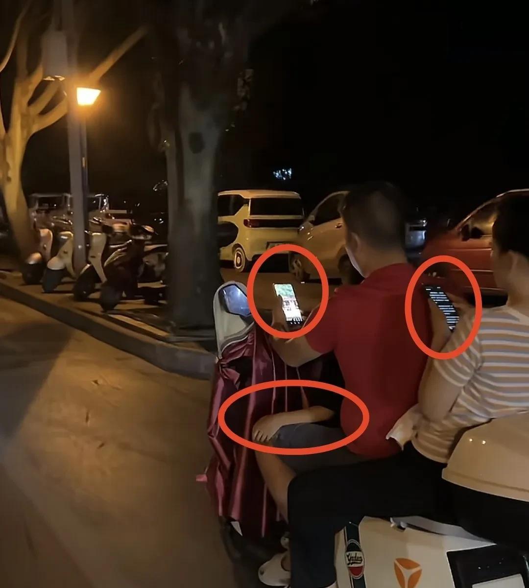 生在这样的家庭也真够倒霉的
前面坐个娃，夫妻两个边骑车边玩手机，一旦有个突发状况