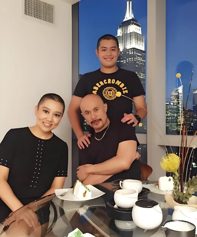这是徐锦江一家在国外吃饭的照片，窗外的帝国大厦很亮眼，后面站着是他儿子徐菲，样子
