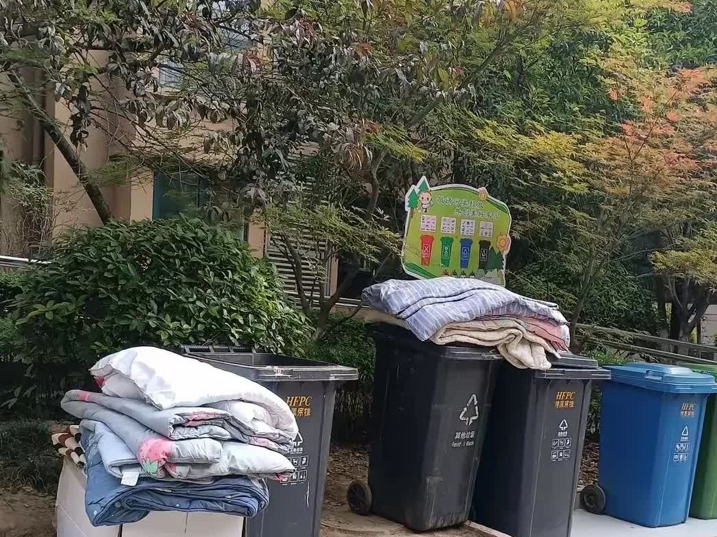 楼下垃圾桶旁又堆满了被褥和生活用品，一定是又有老人去世，儿女来收拾遗物。过去我们