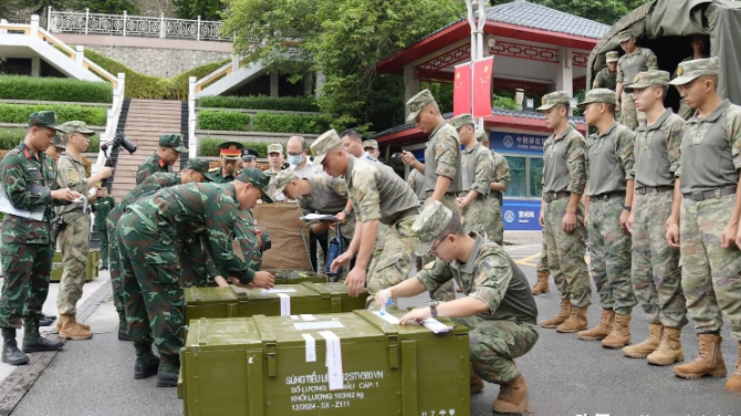 越南的步枪即将运往中国。中越陆军将举行联合训练，两国的工作人员正在密封箱体，准备