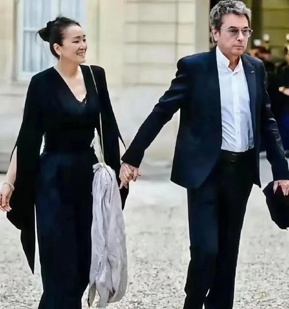 巩俐现任丈夫虽已过花甲之年，身材依然挺拔，气质不错，精神状态极好，手奔着巩俐十分