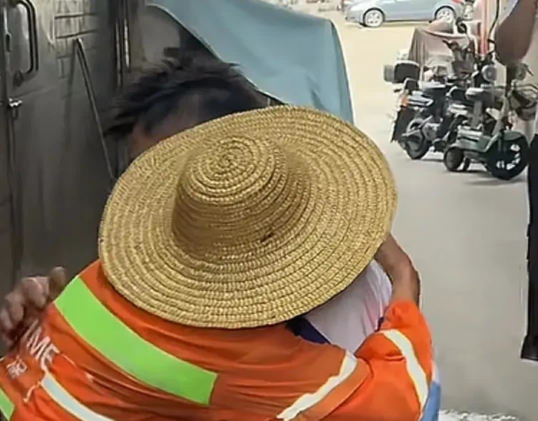 一位环卫工人正在忙碌着工作，一个男孩突然跑过来跪在面前，紧紧抱着环卫工作，他说妈