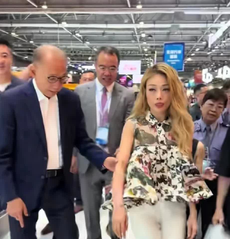 容祖儿和她的老板一起去参观车展。
当下台阶的时候，
她的老板小心翼翼的挽起她