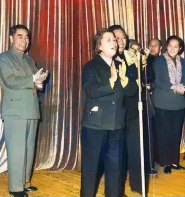 邓颖超在联欢会上唱歌，周总理在她身后鼓掌 ​​​
