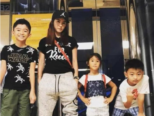 张柏芝身旁的小女孩长得有点像她，四人合影，颇有一家人的感觉