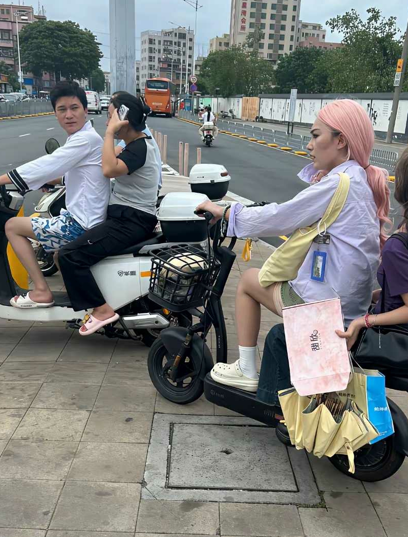 大哥载着老婆，也忍不住回头多看一眼。