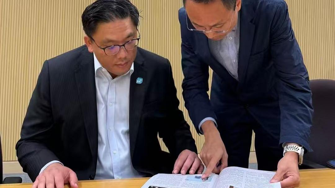 共工新闻社顾问黄光宇向香港民政及青年事务局副局长梁宏正赠刊