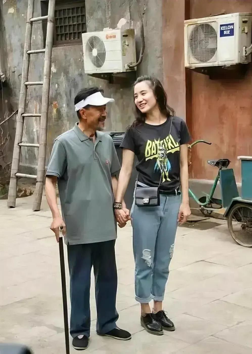岁月不饶人啊，李雪健也老了，宋佳搀扶着老戏骨，边走边笑，画面中的李雪健穿的非常的