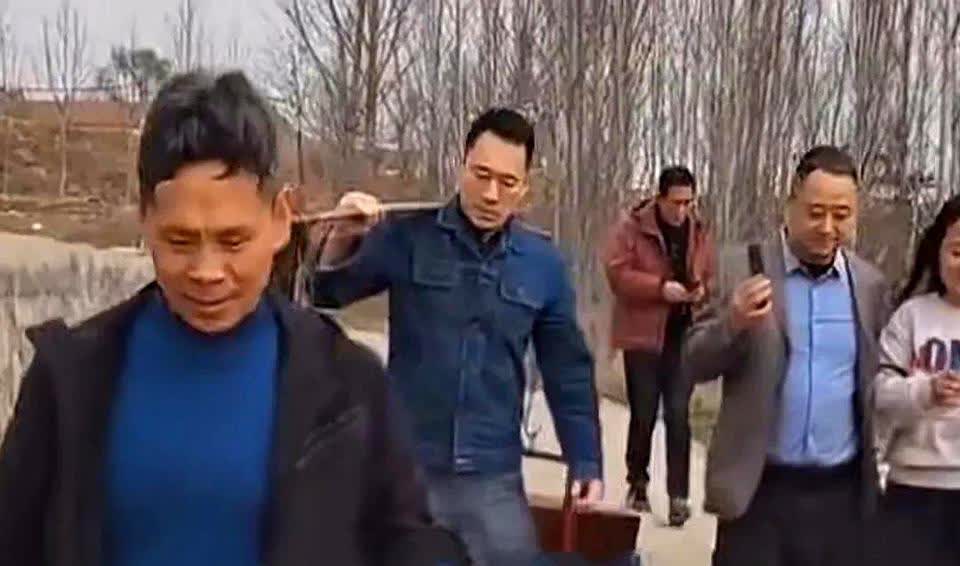 清明节期间，55岁的“武松”丁海峰回老家祭祖，肩上挑着扁担，上穿牛仔外套，灰色裤