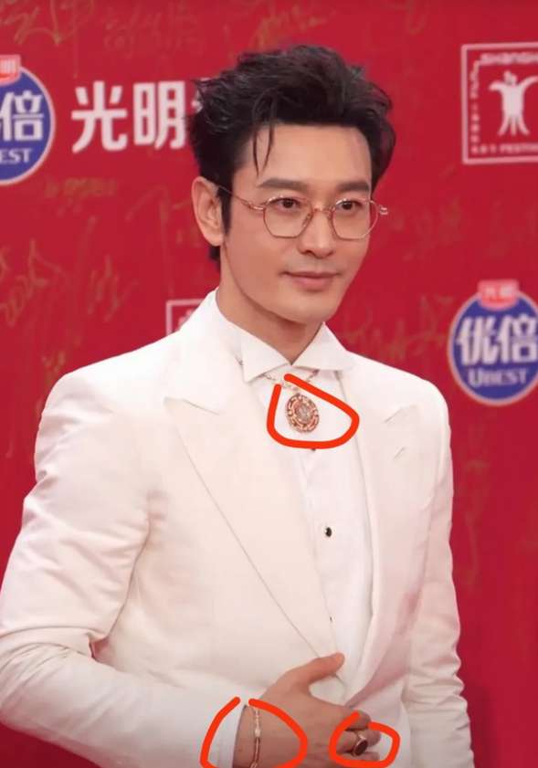 黄晓明身着白色西装亮相上海电影节闭幕式，，脖子上硕大的金色项链配圆盘吊坠、手腕金
