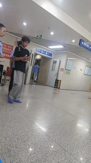 医院里拍到一名戴手铐的男子在两名警察的陪同下来到医院做抽血化验检查。
这名男子看