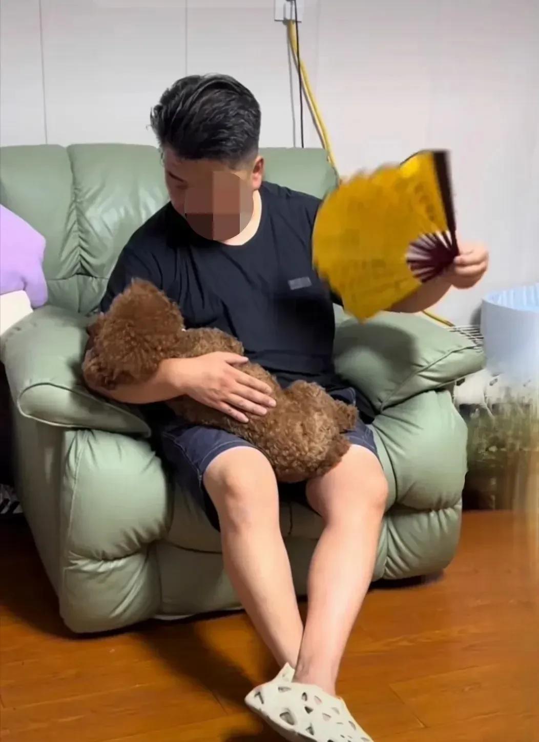 这位先生对狗狗真好，抱在怀里还给它扇着扇子，这么疼爱有加，为什么不开空调呢？
二