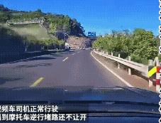 开车遇到这种挑衅的人怎么办？视频车正常行驶，对面来了一辆逆行的摩托车，双方及时刹