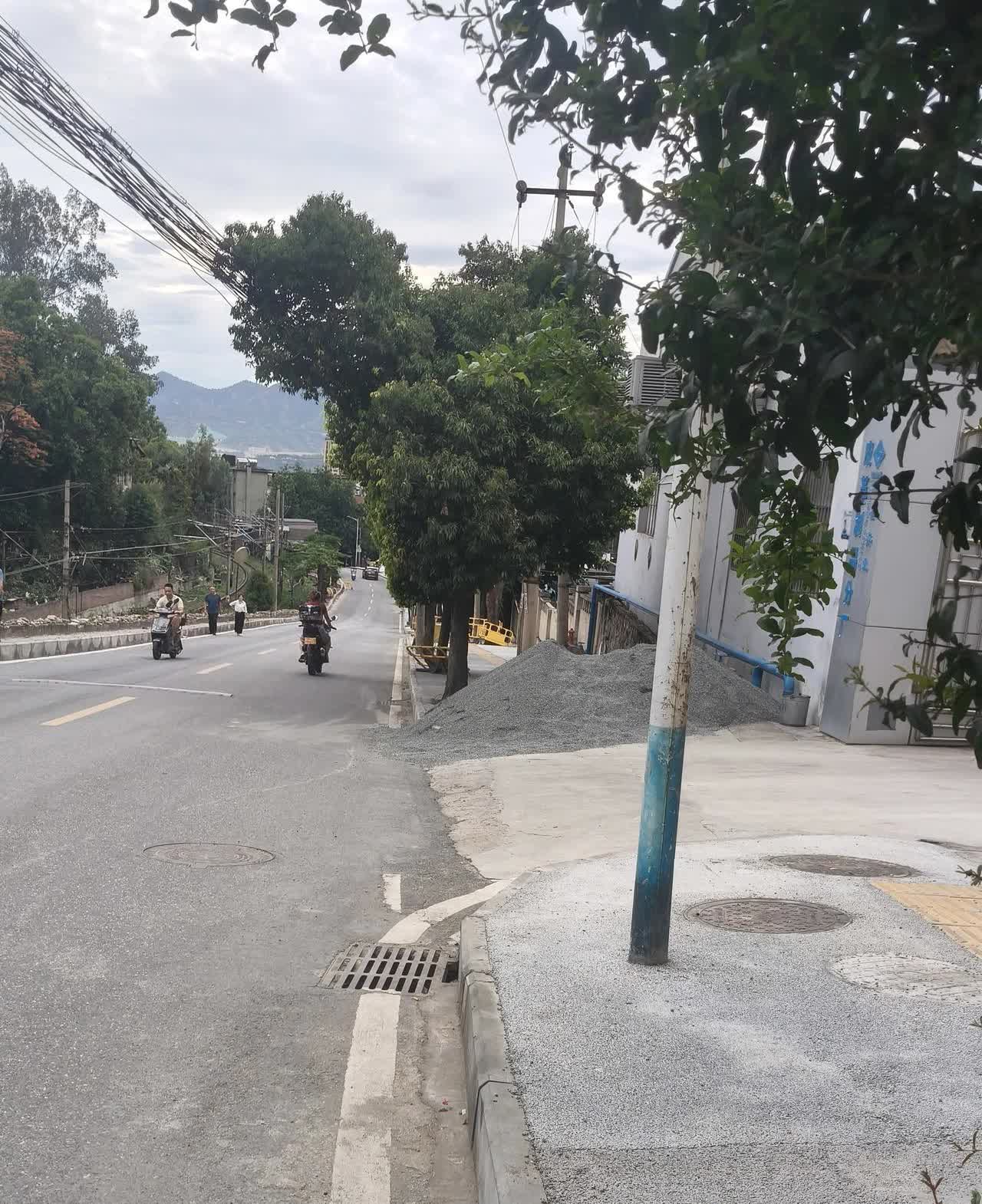 这个路段修路的堆沙把道路堵了，公路上堆着沙，人行道上堆满沙影到过路人学生和老人。