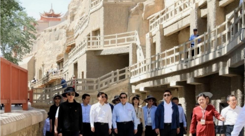 中国台湾省，马英九参访敦煌莫高窟，与游客们打招呼合影。
时间是6月26日上午。