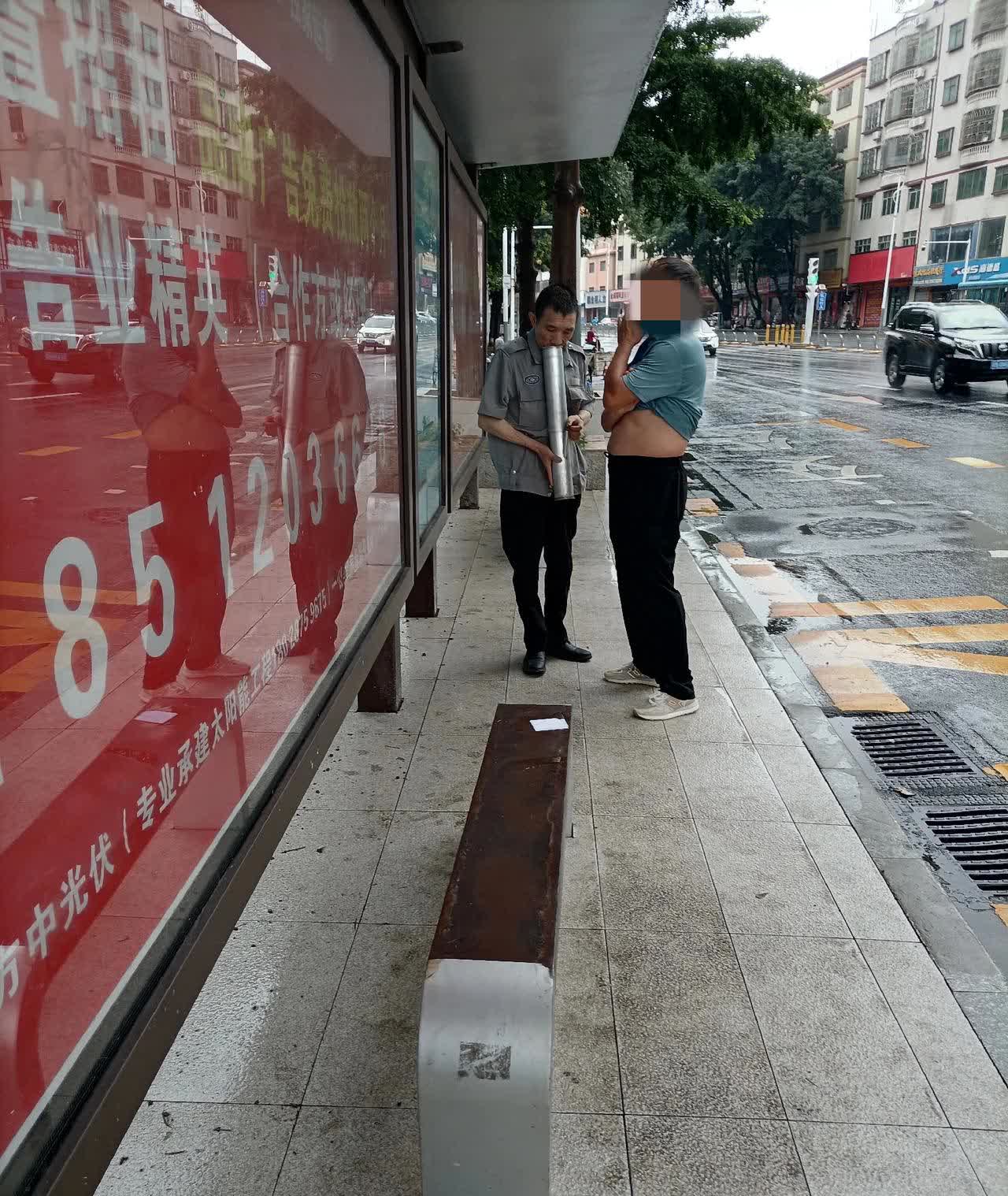 在惠阳立交桥公交站台等车，这是走过来两个中年男人，其中一个怀里抱着一个细长的圆通