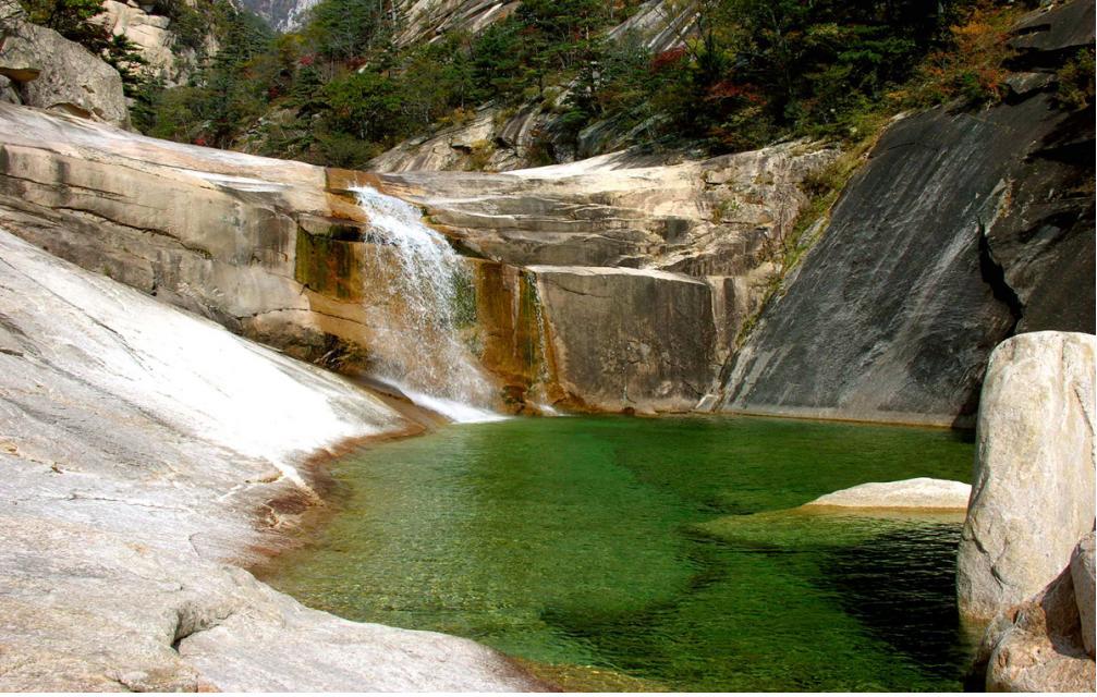 金刚山的溪谷和水潭
朝鲜名山金刚山有巨大的层岩绝壁、千沟万壑、大小水潭，与绿树相